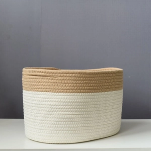 Detail of two-tone woven cotton rope storage basket with brown and white stitched textures
