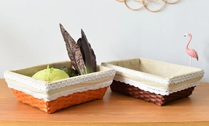 Set of woven storage baskets with floral lace lining on a rustic wooden table