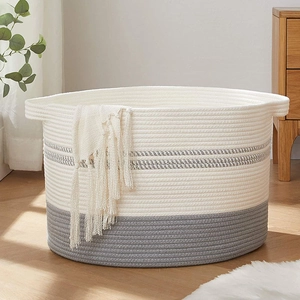 Detail of woven cotton rope laundry basket with grey contrast and side handles