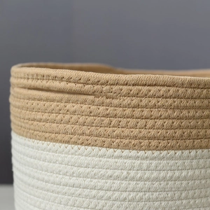 Detail of minimalist woven cotton rope basket showing tight stitching and dual-tone texture
