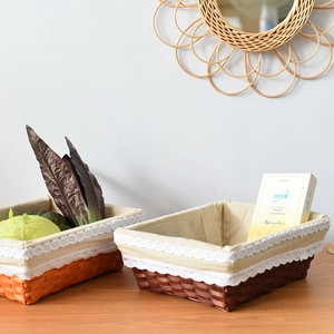 Detail of woven rectangular storage baskets with lace trim and cotton linen lining
