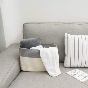 Close-up of woven cotton rope storage basket in grey and white on a modern sofa