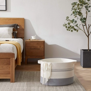 Detail of woven cotton rope storage basket in white and gray with integrated handles