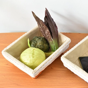 Detail of woven rectangular storage basket with soft cotton lining and lace trim