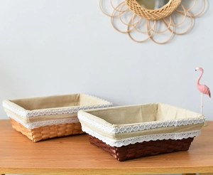 Detail of hand-woven rectangular storage basket with elegant white lace lining edge