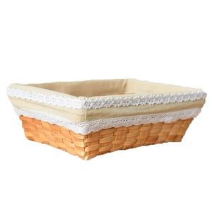 Rectangle wicker storage basket with removable lace-edged linen liner on white background