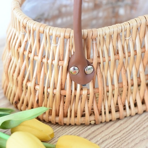 Handwoven wicker flower basket with brown leather handles and waterproof plastic liner