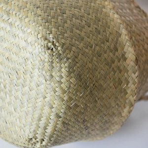 Close-up of natural seagrass woven storage basket showing the intricate cross-weave texture