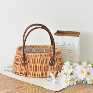 Detail of hand-woven wicker basket with sturdy brown leather handles and waterproof liner
