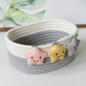 Dettaglio di un cesto in corda di cotone intrecciato con graziose stelle di peluche ricamate