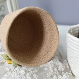Close-up of hand-woven cotton rope storage basket with cute pineapple ornament detail