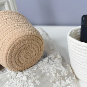 Detailed close-up showing the dense spiral weaving of cotton rope storage baskets