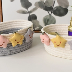 Dettaglio di cesti in corda di cotone intrecciata con simpatiche stelle sorridenti per casa