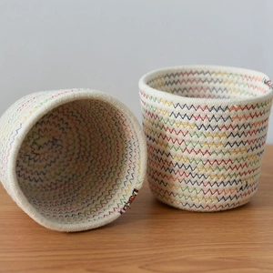 Detail view of woven cotton rope storage baskets with colorful zigzag stitching