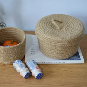 Macro detail of hand-woven jute storage baskets with lids on a wooden tabletop