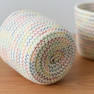 Detailed macro view of woven cotton storage basket with colorful rainbow zigzag stitching