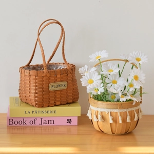 Detail of woven wooden baskets with leather labels, white fringe, and waterproof linings