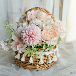 Handcrafted round wicker flower basket with white tassels and elegant silk floral arrangement
