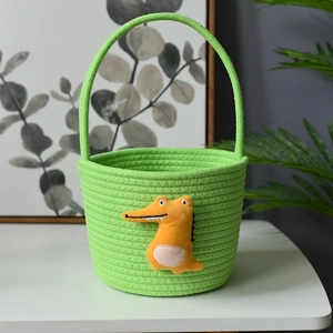 Close-up of woven green cotton rope basket featuring a cute orange crocodile plush toy