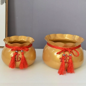 Nahaufnahme goldener chinesischer Neujahrs-Glücksgläser mit roten Quasten und Fu-Zeichen