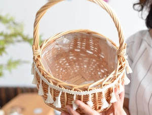 Macro shot of hand-woven wicker basket with white tassels and waterproof plastic lining