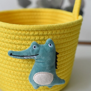 Yellow hand-woven cotton rope storage basket featuring a cute plush crocodile design
