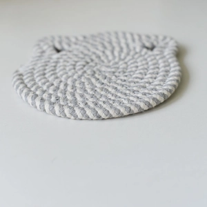 Detailed close-up of a cat-shaped woven heat-resistant cotton rope coaster in gray and white