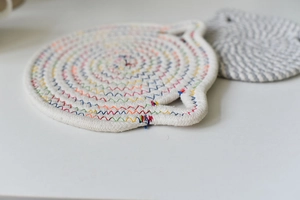 Macro shot of cotton woven heat insulation mat with rainbow stitching and hanging loop