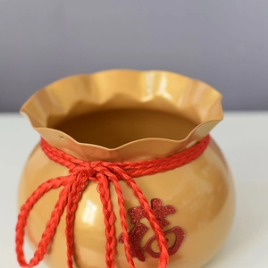 Detail der goldenen Glücksbeutel-Blumenvase mit rotem Seil und chinesischem Fu-Zeichen