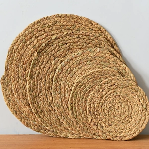 Close-up of five varied sizes of hand-woven straw round heat-resistant table placemats