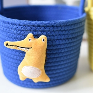 Detailed close-up of blue woven cotton rope basket featuring a cute 3D crocodile patch