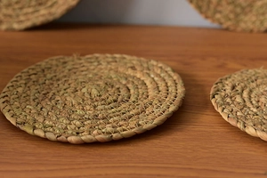 Detailed macro view of a handmade round straw heat insulation pad with spiral weave texture