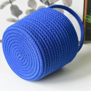 Close-up of dark blue woven storage basket showing spiral braided rope texture