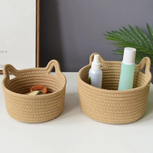 Detail of two beige cotton rope storage baskets featuring decorative cat ear handles