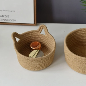 Detail of woven cotton storage baskets featuring cute cat ear handles in khaki color