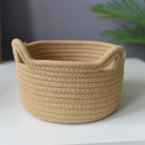 Close-up detail of a minimalist woven cotton rope storage basket with round handles