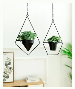 Detail of hanging geometric metal plant holders with black chains in a modern interior