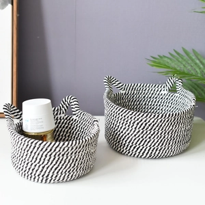 Detail of woven cotton storage baskets set with black and white stripes and round handles