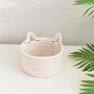 Detail of handwoven cotton rope storage basket with rainbow wavy pattern and cute cat ears