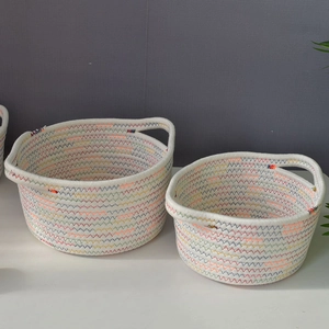 Detail view of woven cotton rope storage baskets with colorful zigzag stitching and handles