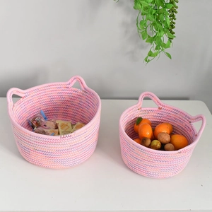 Close-up of pink woven cotton rope storage baskets with cute cat ear handles