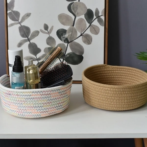 Detail of woven cotton rope storage baskets in white wave and natural styles on tabletop