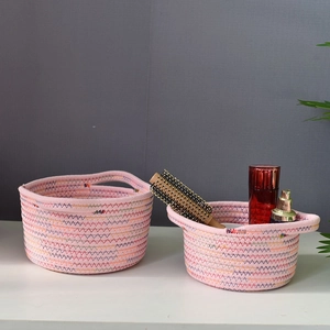 Detail view of pink cotton rope storage baskets with zig-zag stitching and round handles