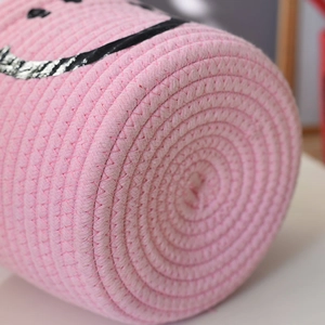 Close-up of the spiral cotton rope weaving pattern on the base of this pink storage basket