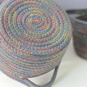 Macro detail of grey cotton rope storage basket with rainbow zigzag stitching texture
