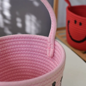 Detail of reinforced cotton rope handle on pink woven storage basket for home