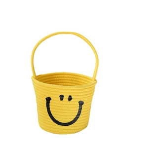 Handwoven yellow cotton rope storage basket with handle and minimalist smile pattern