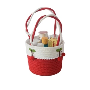 Sac à main en paille tressée avec décor cerise et détails de glands en coton rouge