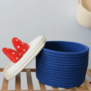 Detail of blue cotton rope storage basket with a red polka dot bow on the lid