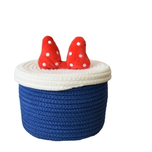 Blue and white cotton rope storage basket with red polka dot bow and lid